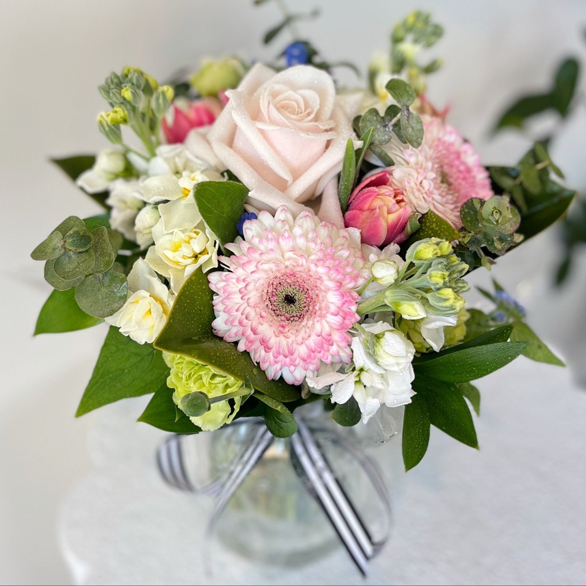Bouquet of flowers in a clear vase on a light background